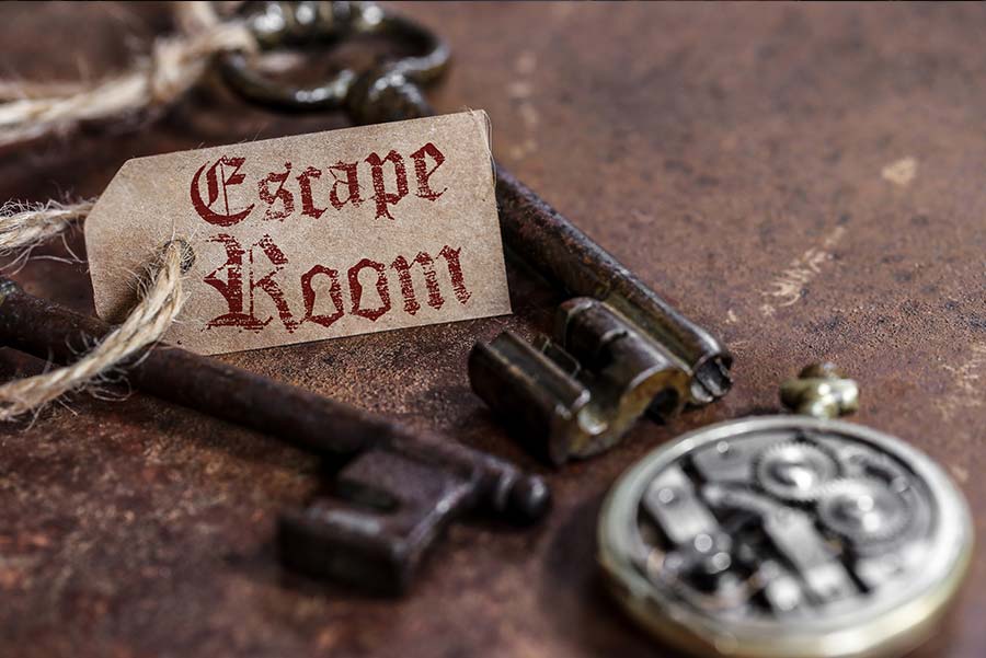 En gammaldags nyckel med tag som det står Escape Room på