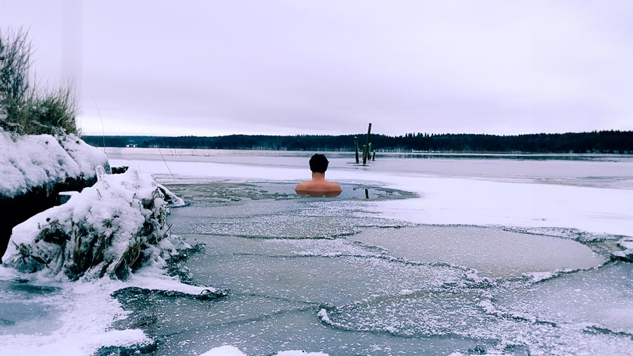 En man vinterbadar i en isvak