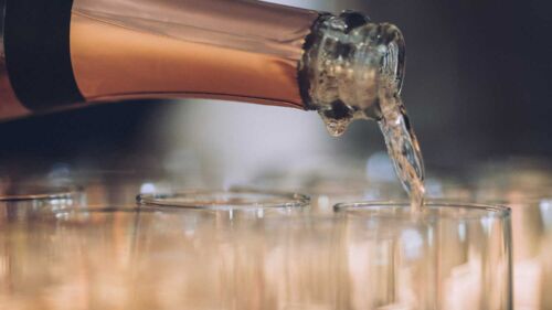 Någon häller upp champagne i glas