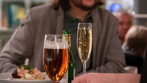Två vänner som äter mat och dricker vin i Uppsala saluhall