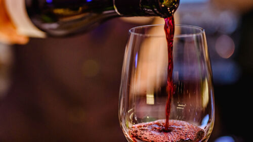Bartender häller upp ett glass rött vin