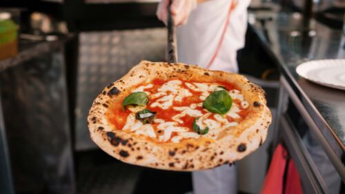 Närbild på en pizzabagare med pizza
