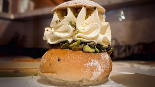 Närbild på en semla täckt med pistagenötter