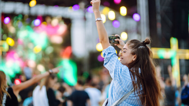 En kvinna tar kort på scenen under en musikfestival