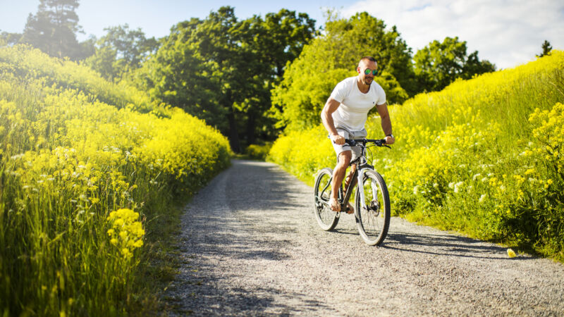 Man som cyklar på grusväg