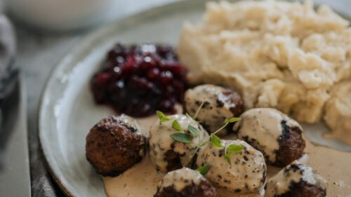 En tallrik med köttbullar,. potatismos och sylt