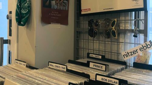 En butik med vinylskivor och solglasögon som hänger på väggen
