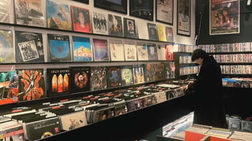 Affär med LP-skivor. Man med svarta kläder kollar på skivorna